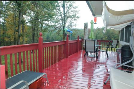 Deck across the back of the home overlooking the property
