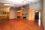 The upper tier of the family room features hardwood floors, fire place and built in entertainment center.